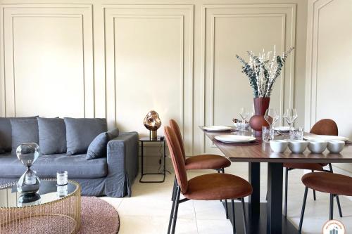 un salon avec une table et un canapé dans l'établissement l'Elégance - Vue dégagée - Balcon - Parking, à Deauville