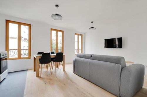 un salon avec un canapé et une table dans l'établissement FlexLiving - T2 - Fessart, à Paris