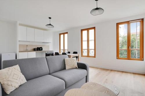 un salon avec un canapé et une cuisine dans l'établissement FlexLiving - T2 - Fessart, à Paris