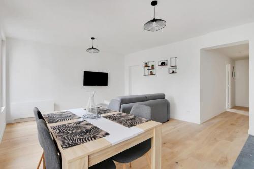 une salle à manger avec une table et un canapé dans l'établissement FlexLiving - T2 - Fessart, à Paris