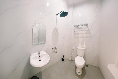 a white bathroom with a sink and a toilet at Simangande View & Resto by Staigo in Ambarita