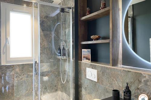 une salle de bain avec douche avec une porte arrière de douche en verre dans l'établissement l'Elégance - Vue dégagée - Balcon - Parking, à Deauville
