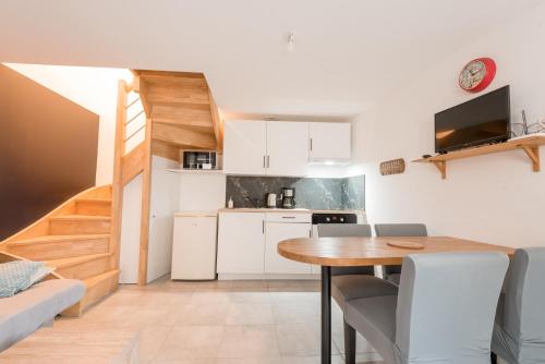 Il comprend une petite cuisine et une salle à manger avec une table. dans l'établissement Le petit Lodge, à Les Rairies
