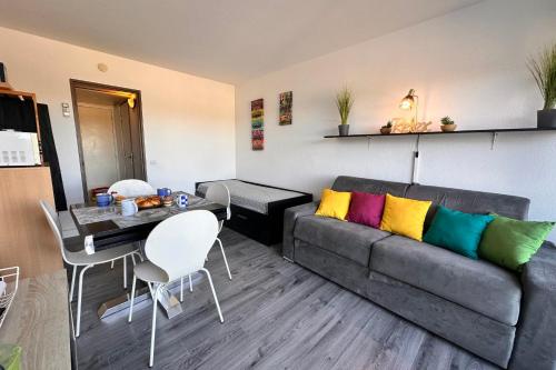 un salon avec un canapé et une table dans l'établissement Studio Les Jardins du Port Port Camargue avec piscine à 2 pas de la plage, au Grau-du-Roi