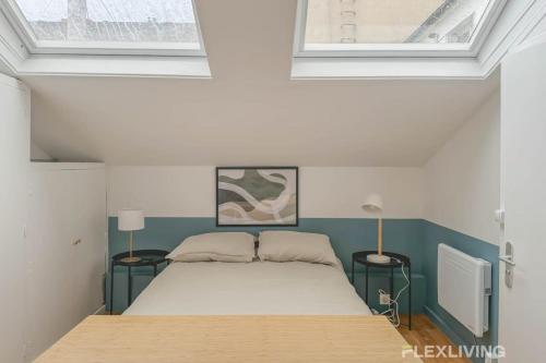 une chambre avec un lit avec deux tables et deux fenêtres dans l'établissement Flexliving - Studio - St Dominique, à Paris