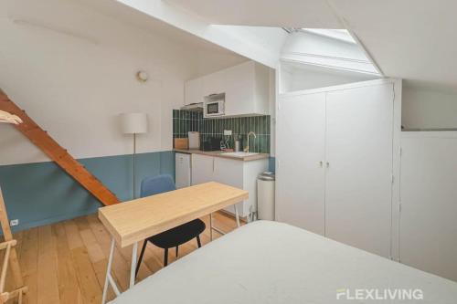 une petite pièce avec une table et une cuisine dans l'établissement Flexliving - Studio - St Dominique, à Paris
