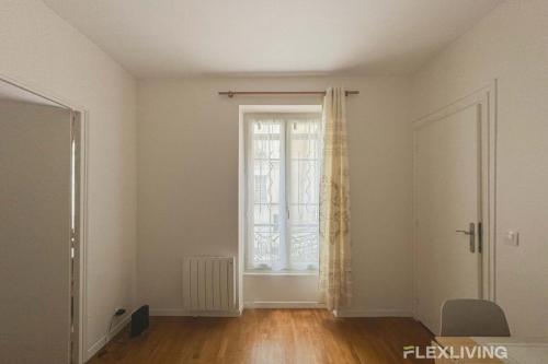 Cette chambre vide dispose d'une fenêtre et de parquet. dans l'établissement Flexliving - whole flat - Villette, à Paris