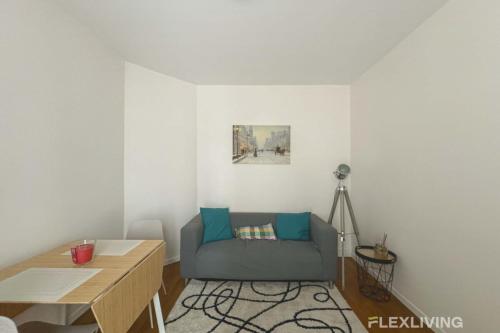 un salon avec un canapé bleu et une table dans l'établissement Flexliving - whole flat - Villette, à Paris