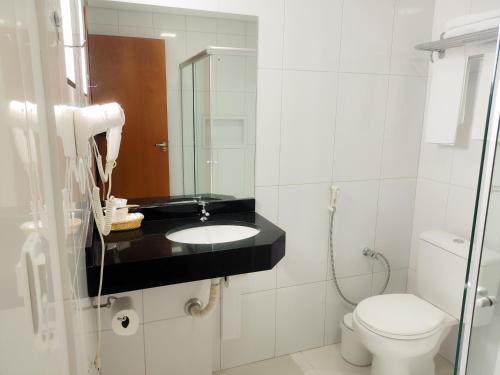 a bathroom with a sink and a toilet at Hotel e Restaurante La Carreta in Tangara da Serra