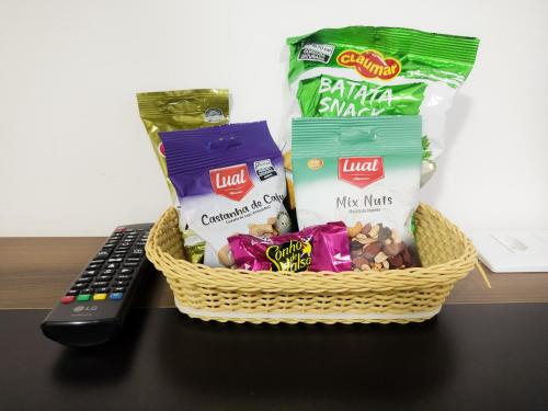 a basket of snacks and chips next to a remote control at Hotel e Restaurante La Carreta in Tangara da Serra