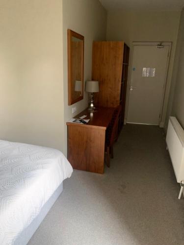 a bedroom with a bed and a desk and a mirror at Cuckoos Corner in Teach Munna