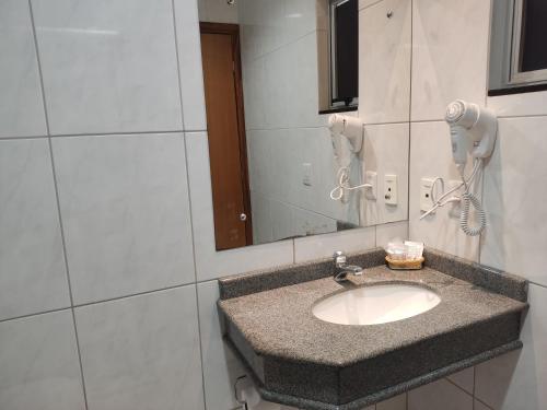 a bathroom with a sink and a mirror at Hotel e Restaurante La Carreta in Tangara da Serra