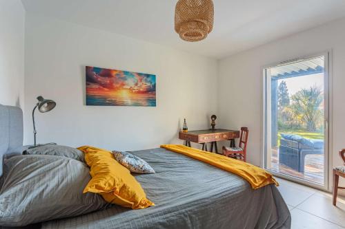 une chambre avec un lit, une table et une fenêtre dans l'établissement BALEA Grand appartement avec SPA de Nage au cœur de Chiberta, à Anglet