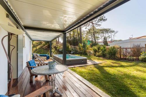 un patio avec une piscine et une table sur une terrasse dans l'établissement BALEA Grand appartement avec SPA de Nage au cœur de Chiberta, à Anglet
