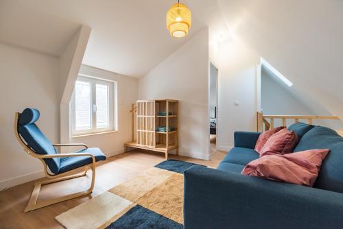 ein Wohnzimmer mit einem blauen Sofa und einem Sessel in der Unterkunft Charmante Maison Bretonne au Cœur de l'Île Grande in Pleumeur-Bodou