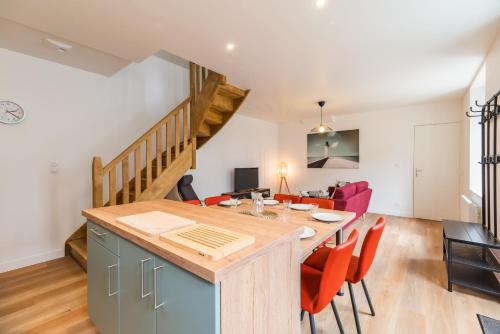 une cuisine et un salon avec une table et des chaises dans l'établissement Charmante Maison Bretonne au Cœur de l'Île Grande, à Pleumeur-Bodou