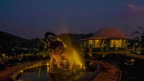a statue of a woman in a fountain at night at Chebera Elephant Paw Lodge in Bokdē