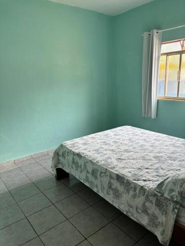 a bed in a blue room with a window at Casa de Vovó in Pedra Menina