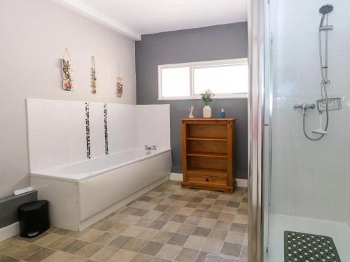 y baño con bañera blanca y ducha. en 4 Trafalgar Square - 3 Bed House - Great Yarmouth, en Great Yarmouth