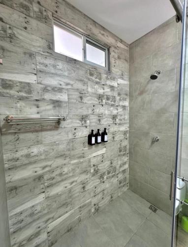 a bathroom with a stone wall with a shower at Casa campestre en el Eje Cafetero in Circasia