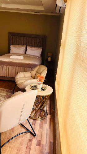 a bedroom with a bed and a table and chairs at Laicah House in Tlokweng
