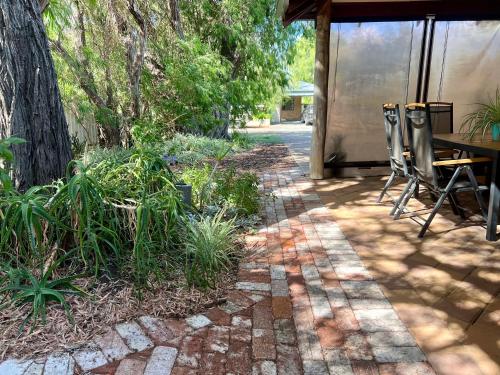 a patio with two chairs and a table and trees at Acacia Retreat in Dunsborough
