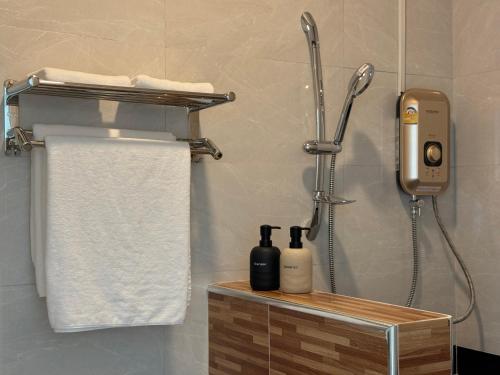 a shower in a bathroom with a phone and towels at Vanida Hotel in Vientiane