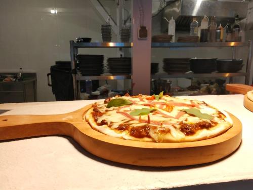 a pizza sitting on top of a wooden cutting board at Dive dude belongas Lombok Mandalika in Blongas