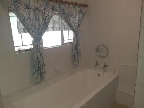 a bath tub in a bathroom with a window at Cottage 2 at Cynthias Country in Hartbeespoort
