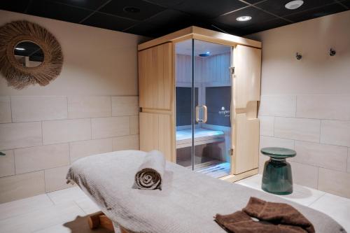 a bathroom with a shower and a bed with a towel at Keystone Hôtel & Spa in Lyon