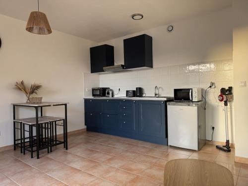 une cuisine avec des armoires bleues et un comptoir dans l'établissement Chez Ti Loulou, à Port-Saint-Louis-du-Rhône