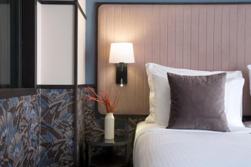 a bedroom with a bed and a table with a lamp at Athens Key Hotel, Trademark Collection by Wyndham in Athens