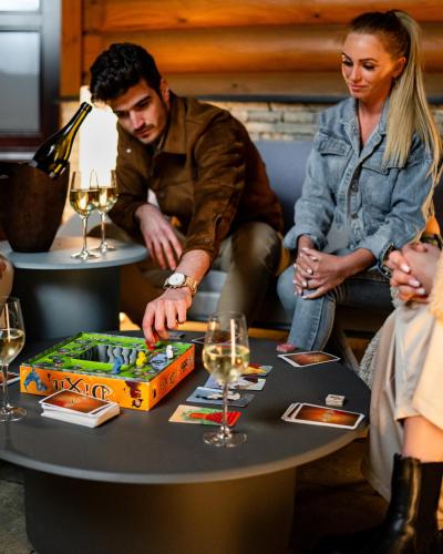 a man and woman playing a board game on a table at Avalon Resort & SPA in Miskolctapolca