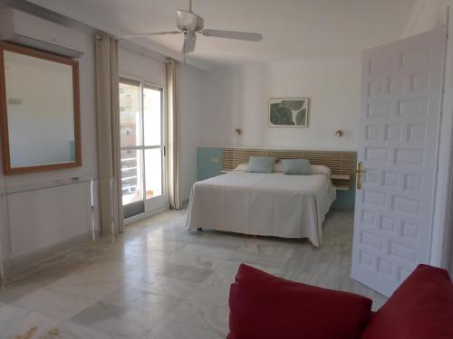 Una habitación blanca con una cama y una ventana en Duplex with sea view, en Roquetas de Mar