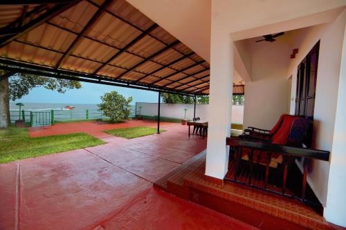 a porch of a house with a view of the ocean at ILLIKKALAM Lakeside Cottages Kumarakom Kerala in Kumarakom