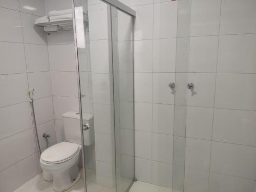 a bathroom with a toilet and a glass shower at Hotel e Restaurante La Carreta in Tangara da Serra