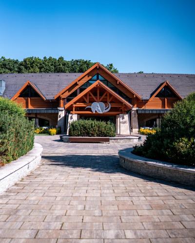 a building with a brick walkway in front of it at Avalon Resort & SPA in Miskolctapolca