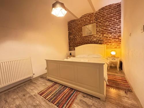 a bedroom with a bed and a brick wall at Apartament Ultra Central in Sighişoara