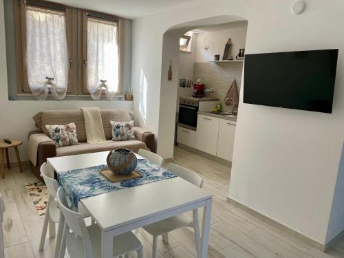 a living room with a table and a kitchen at Casa Manila Isola d'Elba in Portoferraio