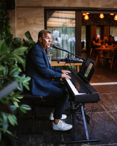 a man playing a keyboard with a microphone at Avalon Resort & SPA in Miskolctapolca