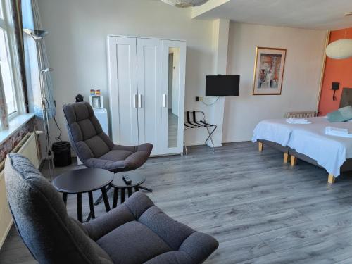 a living room with two chairs and a bed at Hotel Saint Vincent in Poeldijk