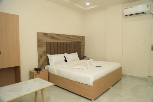 a bedroom with a large bed with a wooden headboard at Hotel VARRAHI EXOTICA in Hyderabad