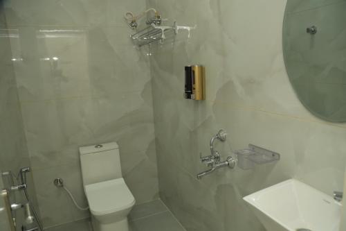 a bathroom with a toilet and a sink and a mirror at Hotel VARRAHI EXOTICA in Hyderabad