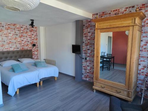 Un dormitorio con una cama, un espejo y una mesa. en Hotel Saint Vincent, en Poeldijk