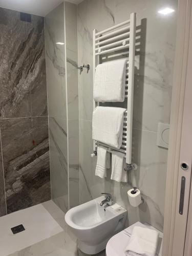 a white bathroom with a sink and a toilet at JR Hotels Bocconi Milano in Milan