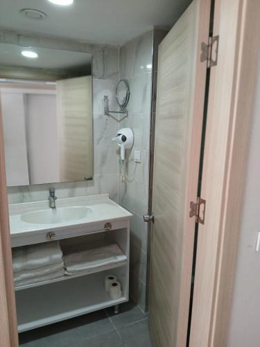 a bathroom with a sink and a shower with a mirror at Pirates Park Resort - All Inclusive in Kemer
