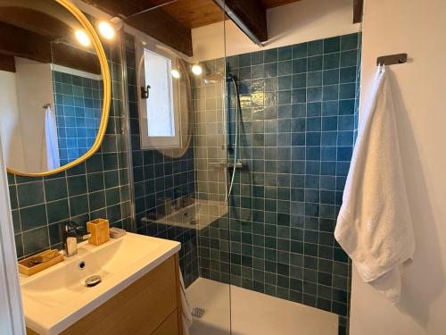 La salle de bains est pourvue de carrelage vert, d'un lavabo et d'une douche. dans l'établissement Appartement avec mezzanine de vacances à 7 min de la plage, aux Lecques