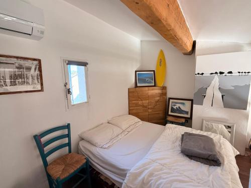 une petite chambre avec un lit et une chaise dans l'établissement Appartement avec mezzanine de vacances à 7 min de la plage, aux Lecques
