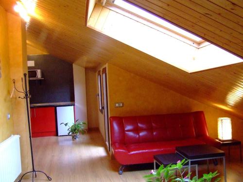 a living room with a red couch and a skylight at Apartamentos Rurales Altuzarra in Ezcaray