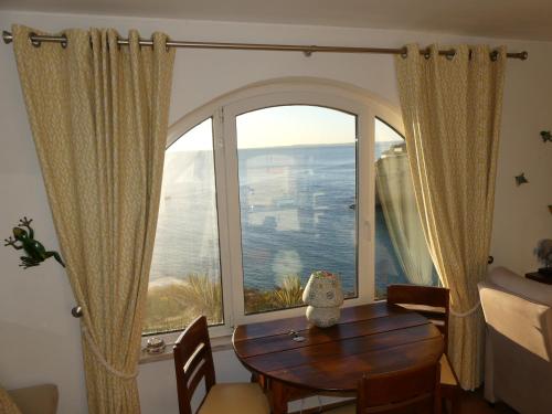 a room with a table and a large window at CastelloHouse, The Best Sea View, in front of Carvoeiro beach in Carvoeiro